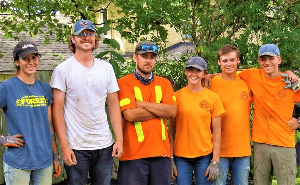 six people happily smiling as part of the Riverwood landscaping team