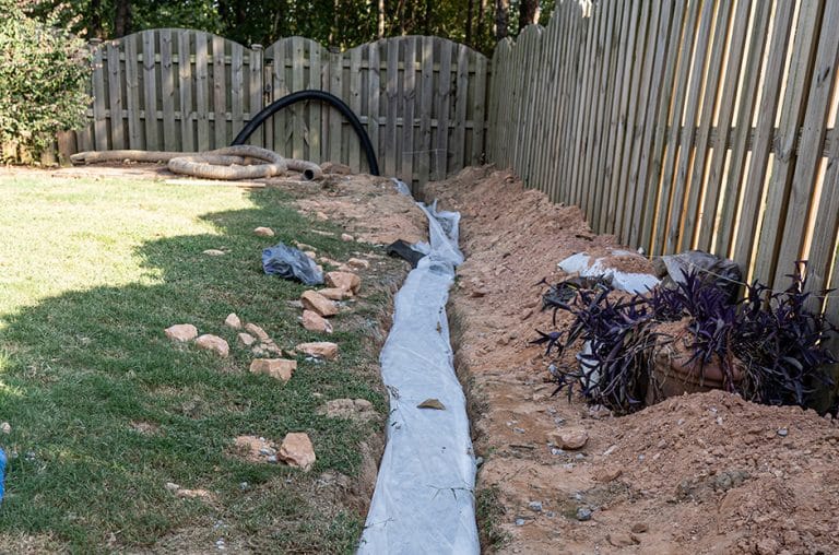 Installing a french drain beside fence in Guelph backyard