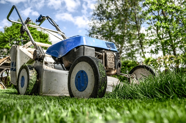 a lawn mower sitting on top of a lush green field.
