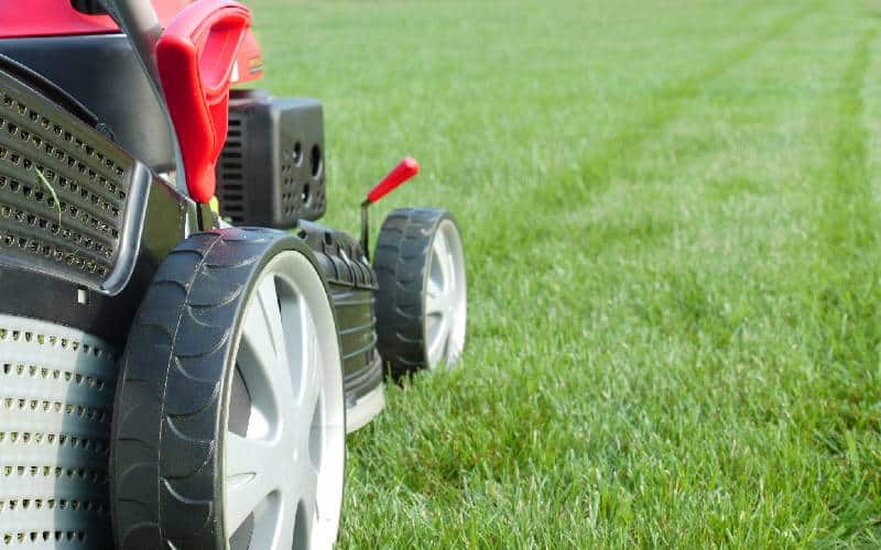 A lawn mower is parked on a grassy field.
