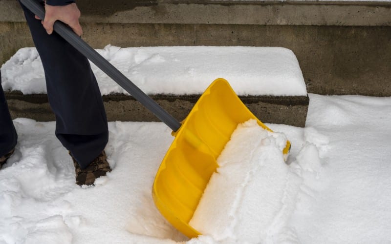 man big snow shovel cleans sidewalk winter winter time job