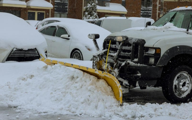 heavy snowfall snowplow truck removes snow parking lot